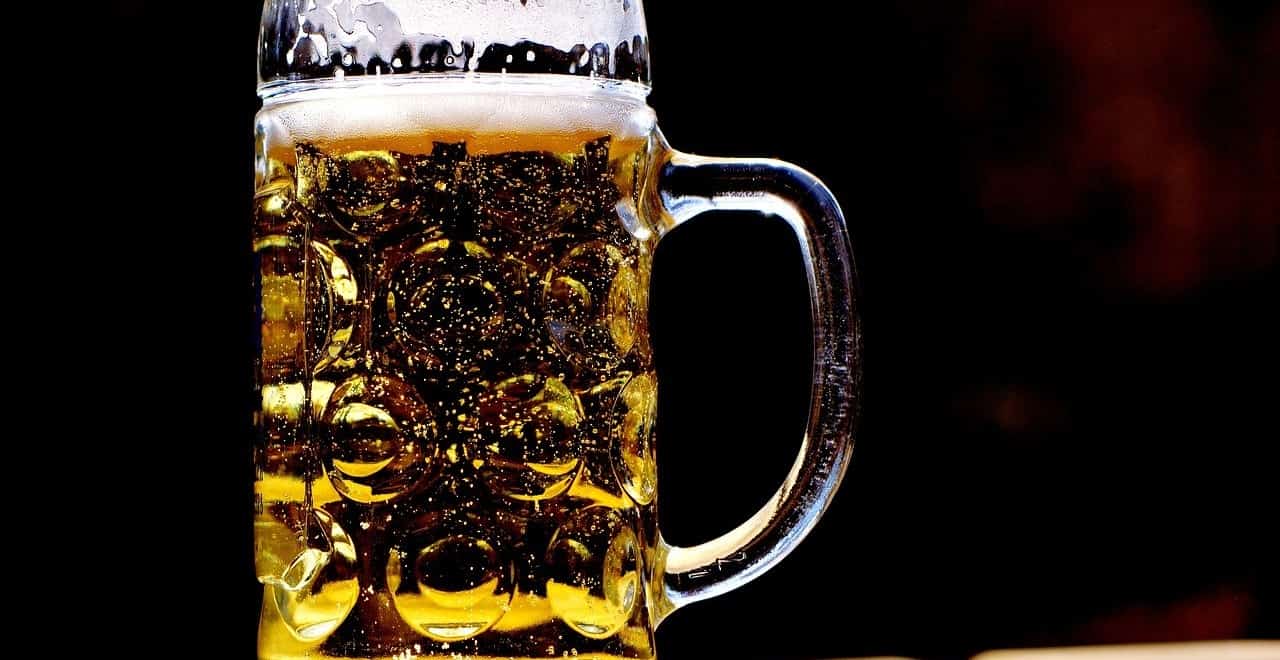 Voller Bierkrug vor schwarzem Hintergrund
