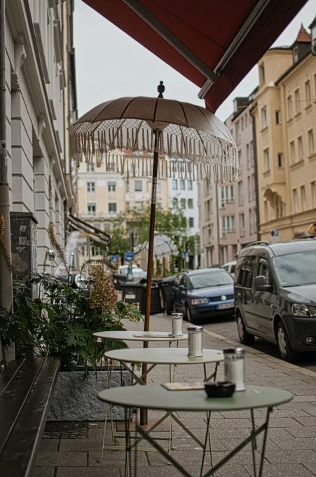 Kleine runde Tische mit Salzstreuer von einem Straßencafé in München