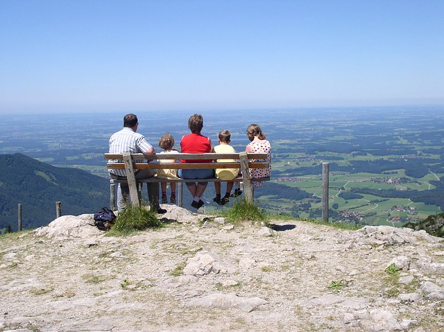 Familie hockt auf Bank auf Gipfel der Kampenwand nahe Chiemgau, München